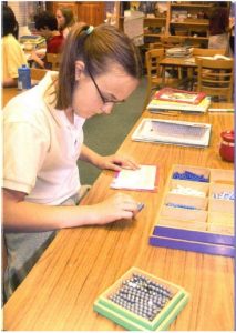 CMS - Centurion Montessori School learner, working independently as she practices her mathematics equations, using the bead activity